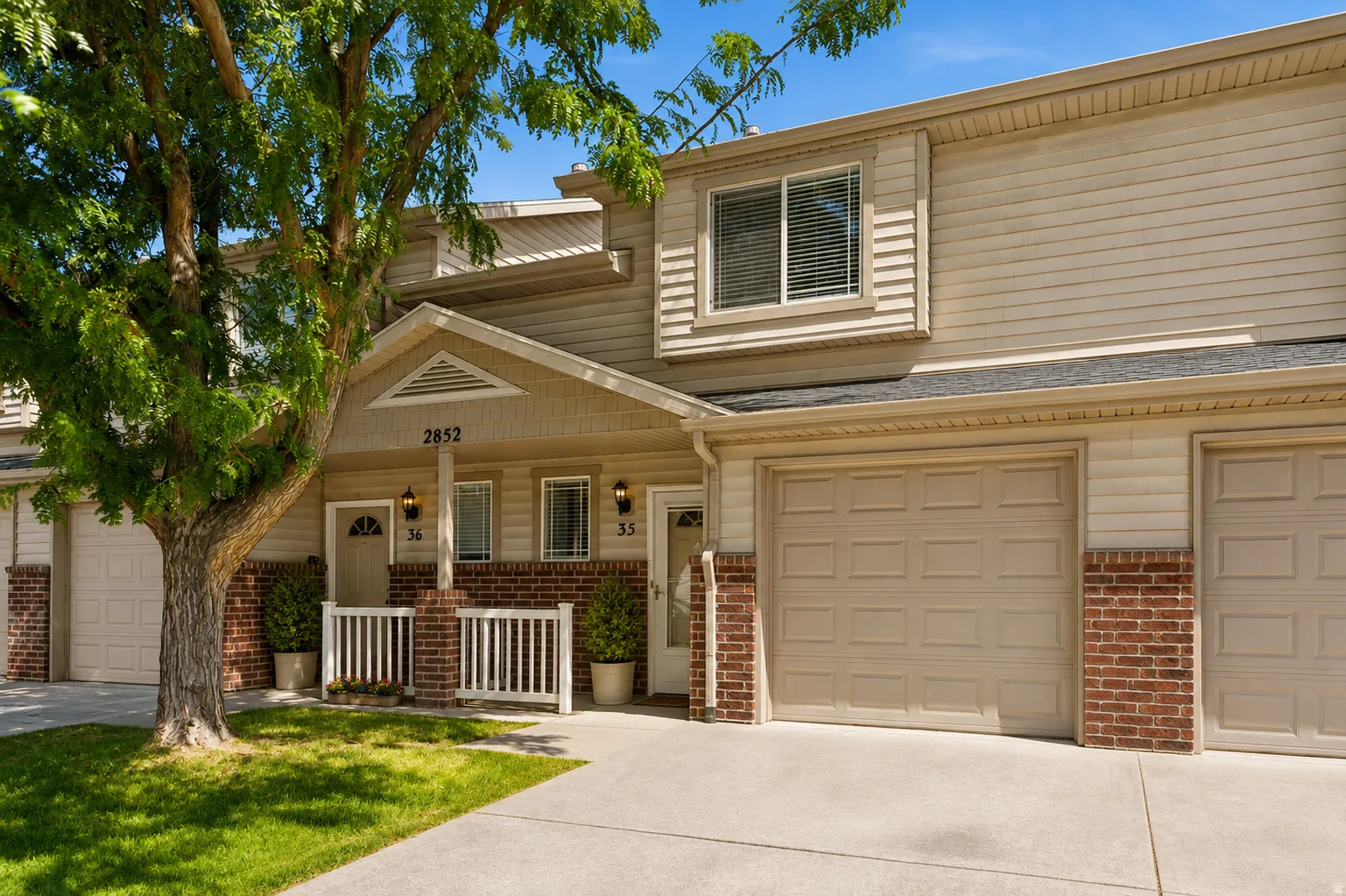 Exterior facade featuring beige siding, brick accents, and a covered entry