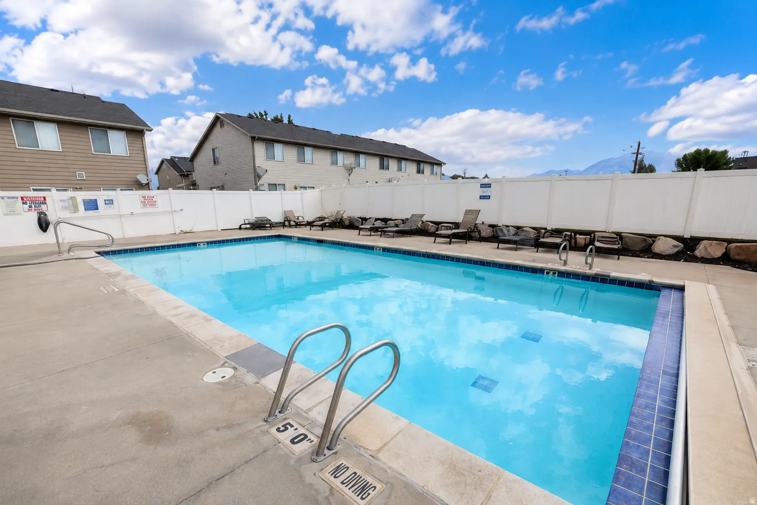 Outdoor swimming pool with integrated steps, surrounded by a concrete deck