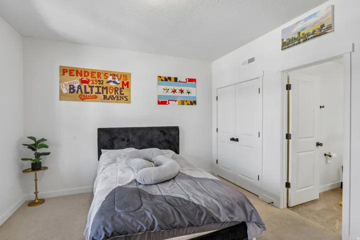 Carpeted room featuring white walls, a built-in closet with bifold doors, and a solid core door leading to an adjoining space