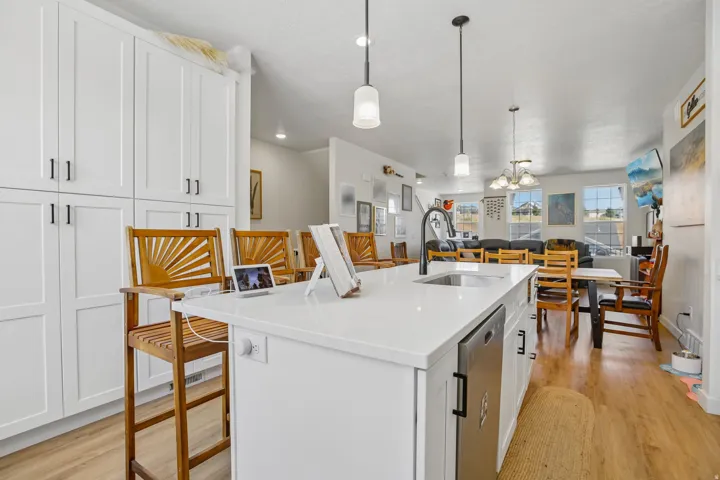 White kitchen island with a built-in sink, matte black faucet, and integrated appliance
