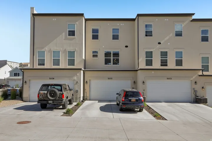 Contemporary townhome facade featuring a neutral stucco exterior