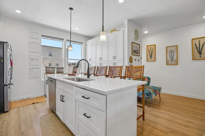 Kitchen island featuring a white countertop with an undermount sink and black faucet