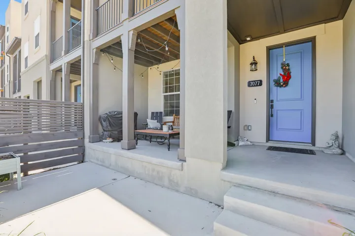 Front patio entry featuring a vibrant blue door, overhead recessed lighting, and an exterior lantern
