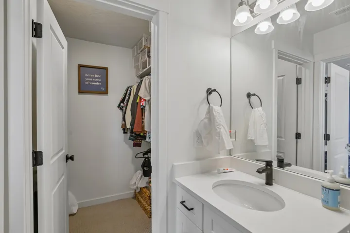 Vanity with an integrated oval sink, white countertop, and matte black faucet