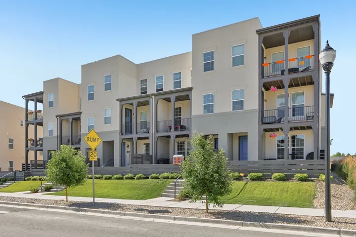 Contemporary multi-story townhome residences featuring stucco exteriors and tiered balconies with dark railings