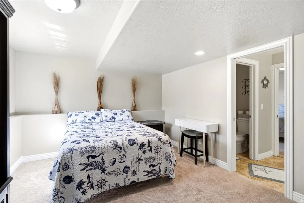 Carpeted sleeping area with recessed lighting and a built-in half-wall feature