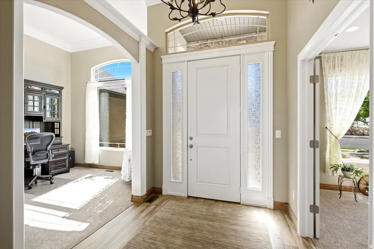 Entryway featuring a white paneled door with frosted glass sidelights and an arched transom window