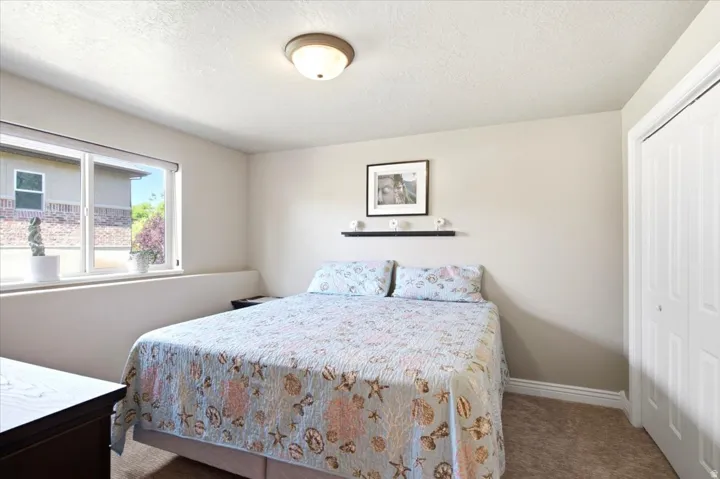 Bedroom featuring carpet flooring, a multi-pane window, and a built-in closet with bi-fold doors