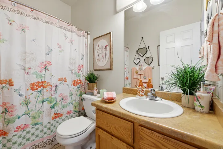 Bathroom featuring a light wood-finish vanity with a built-in oval sink and a light-colored countertop