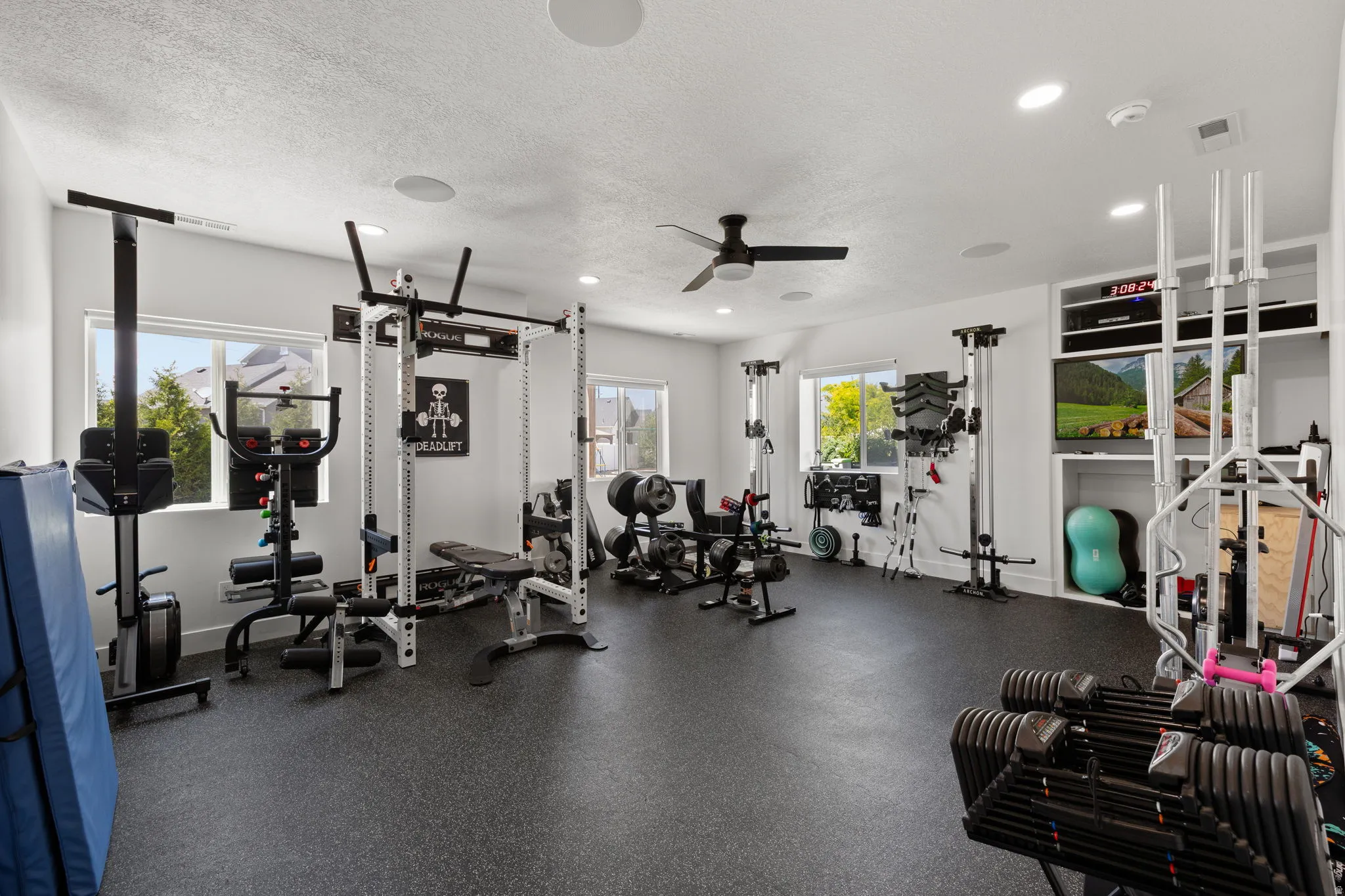 Dedicated workout room featuring specialized rubber flooring, recessed lighting, and multiple windows