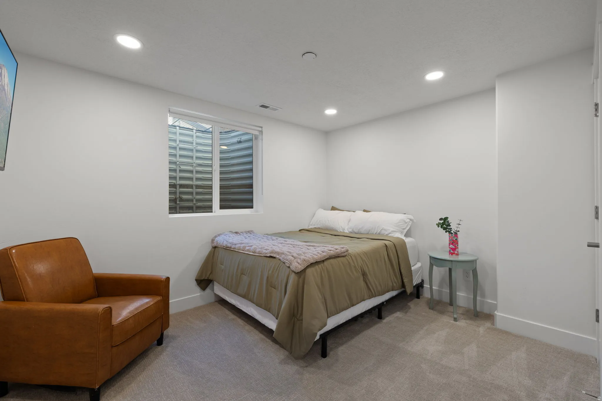 Carpeted room featuring a window with a window well, white walls, recessed lighting, and white baseboards