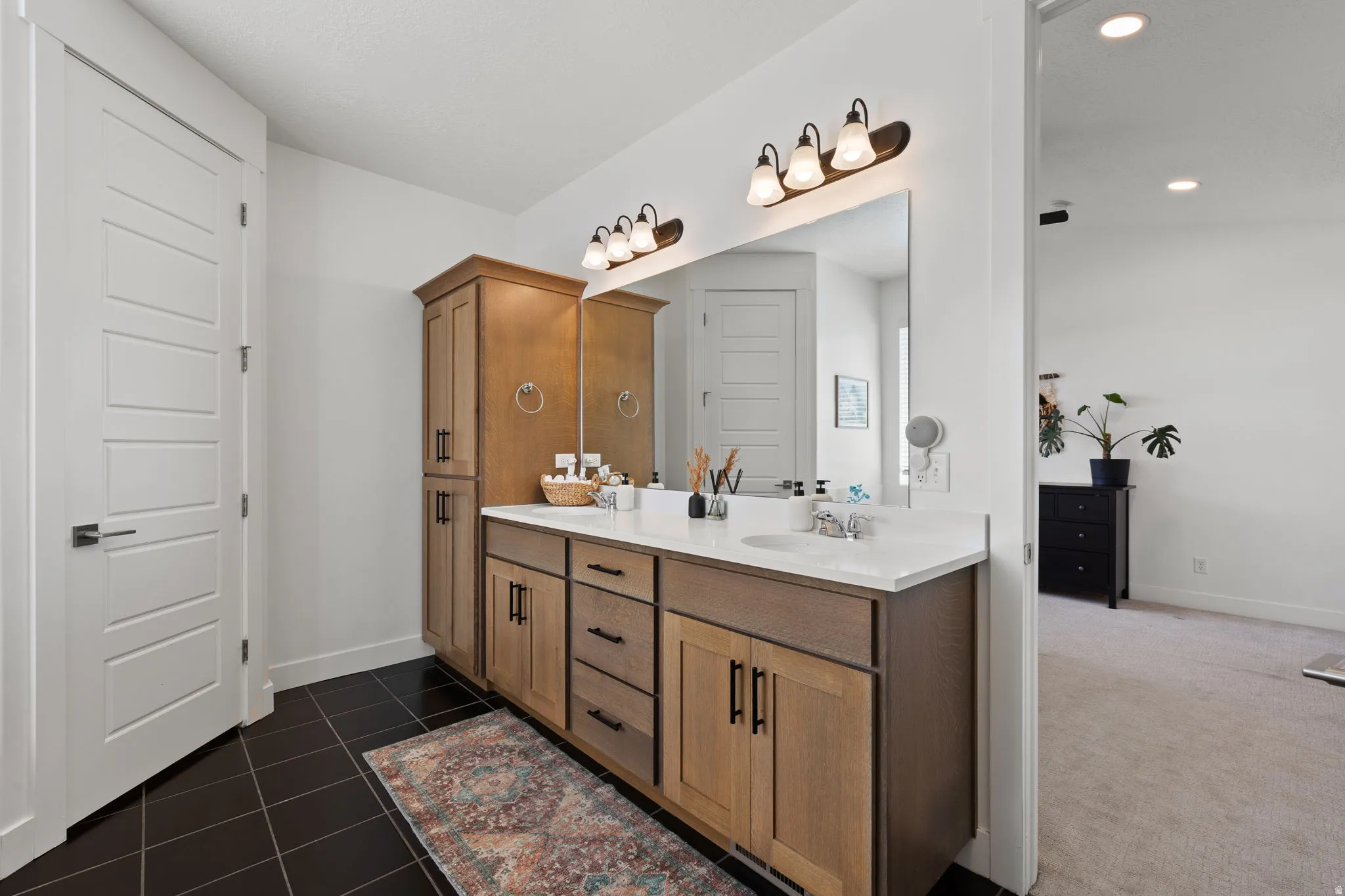 Double vanity with undermount sinks, white countertop, and dark wood-finish cabinetry