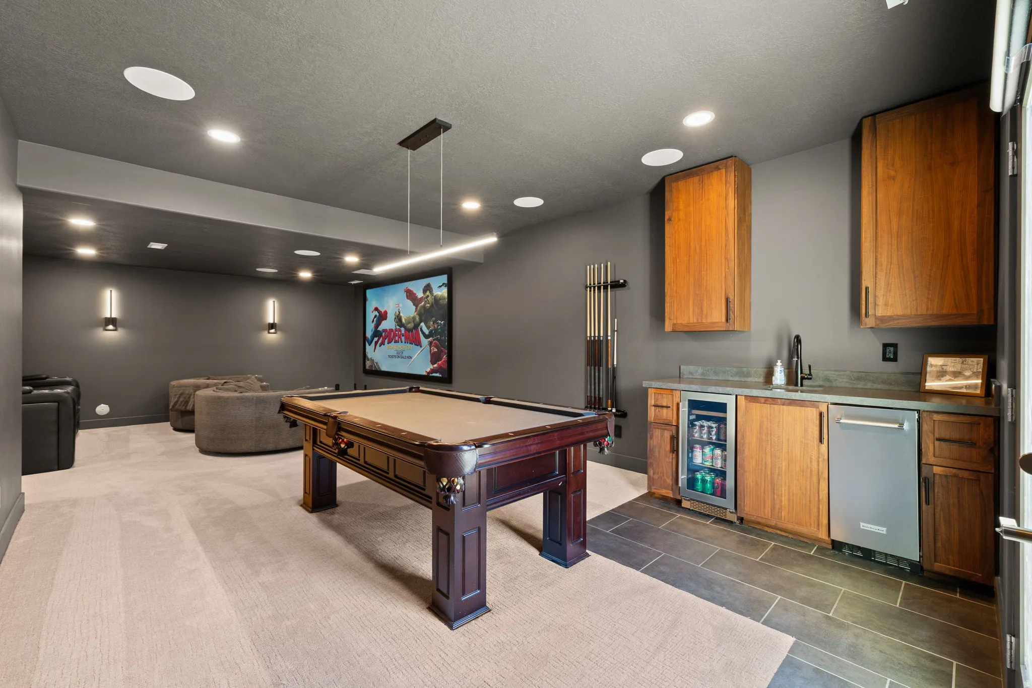 Recreational space featuring a large projection screen, recessed lighting, and modern wall sconces