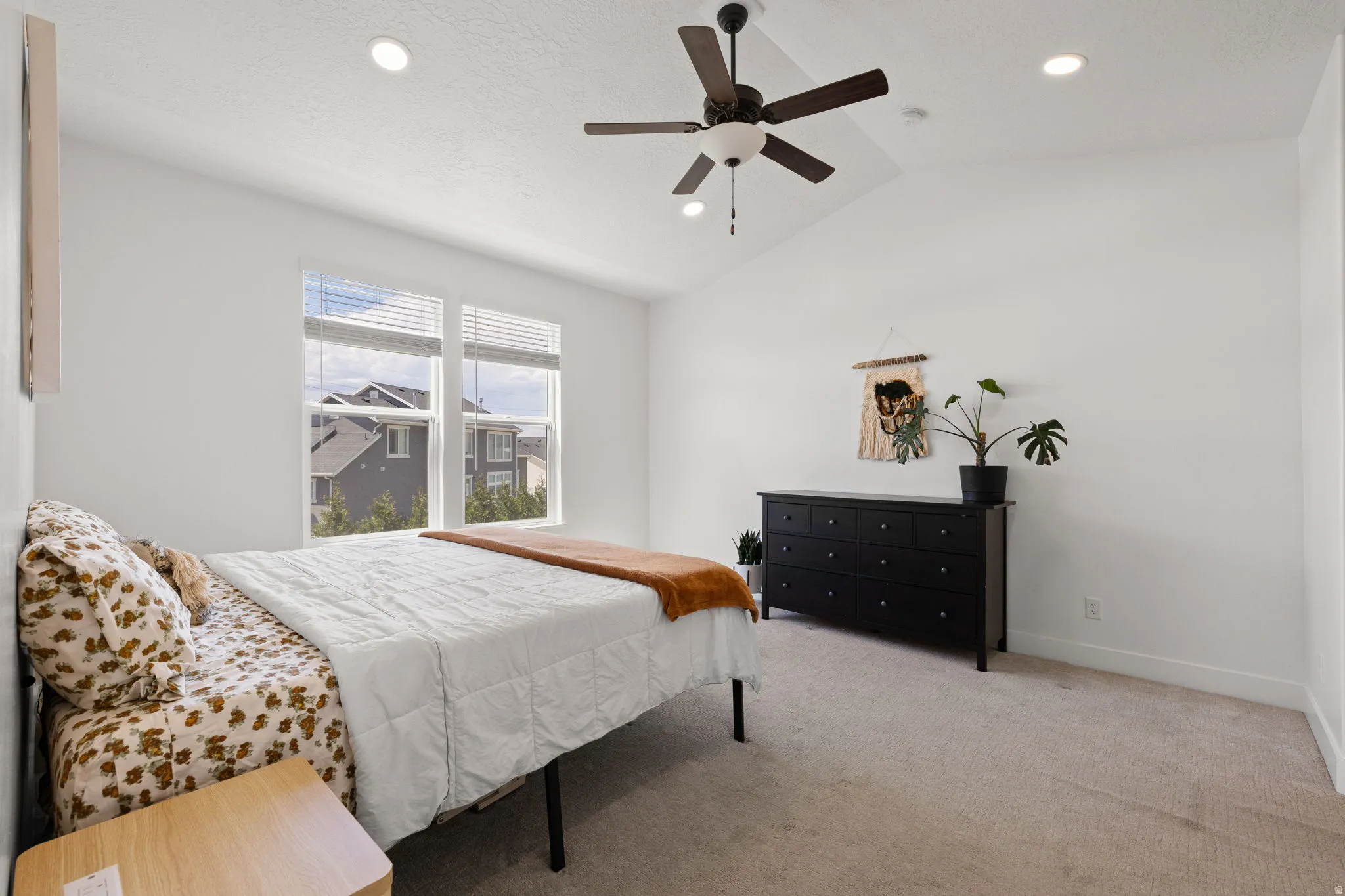 Vaulted ceiling with a ceiling fan and recessed lighting, large windows with blinds, and neutral carpeting