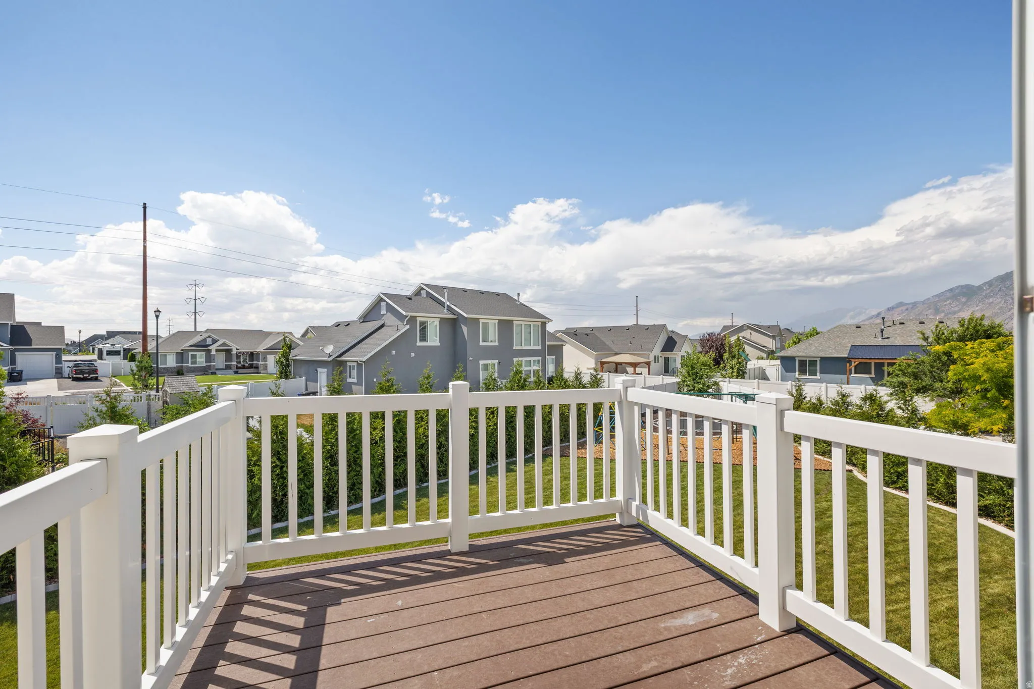 Spacious elevated deck with composite wood-finish flooring and white railings