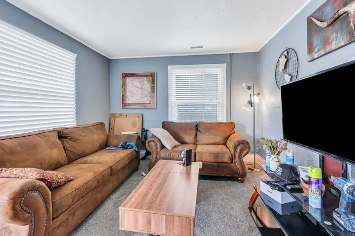 Rental: Living area featuring neutral wall paint, white window blinds, and carpet flooring