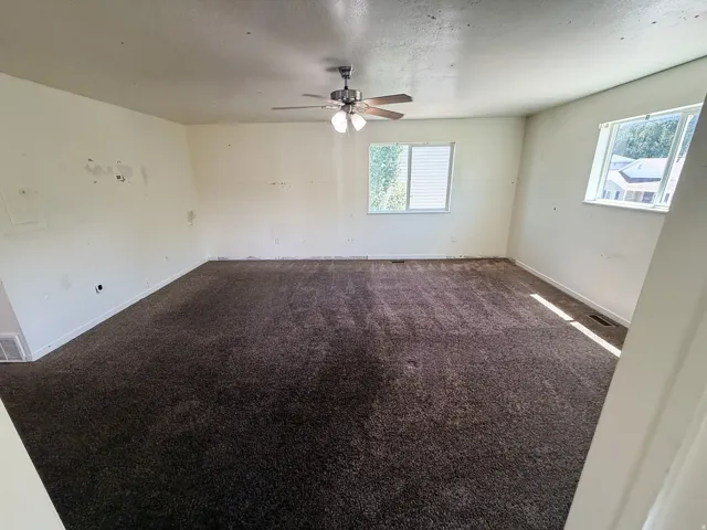 Spacious room featuring neutral carpeting and light-toned walls