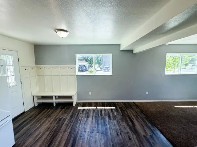 Entryway featuring wood-finish flooring, a built-in hall tree with bench seating and storage, a white paneled door with decorative glass, and a semi-flush mount ceiling fixture