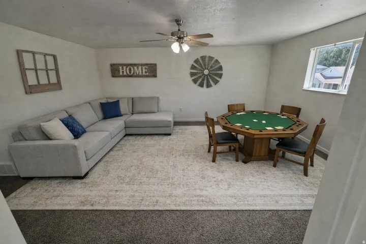 Spacious room featuring a ceiling fan with light fixture, neutral wall finishes, and a window providing natural illumination