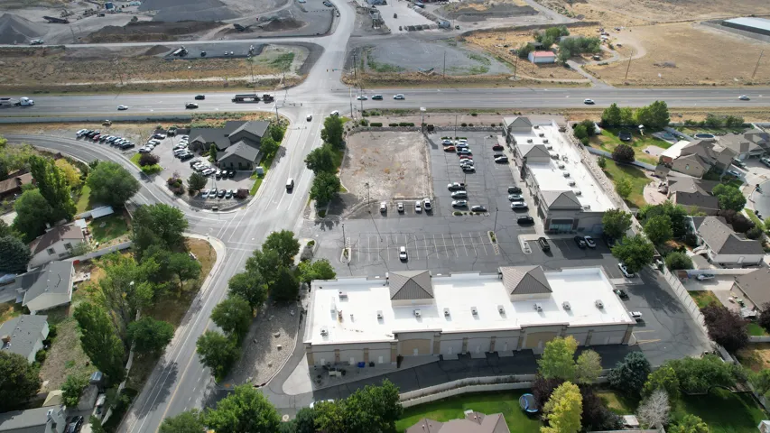 Aerial perspective showcasing commercial properties with multiple buildings, surface parking, and road infrastructure