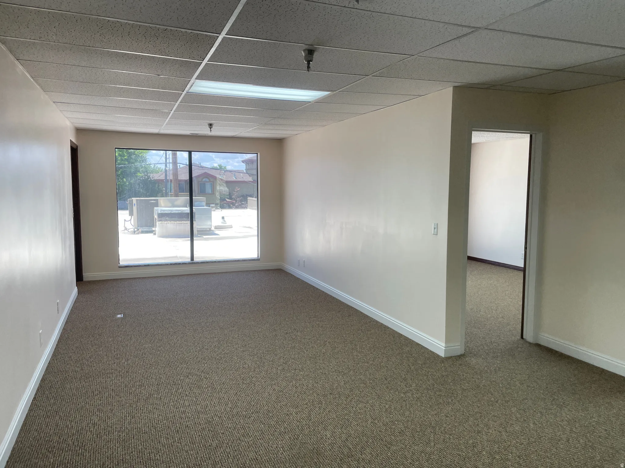 Spacious room featuring broadloom carpeting and neutral wall tones