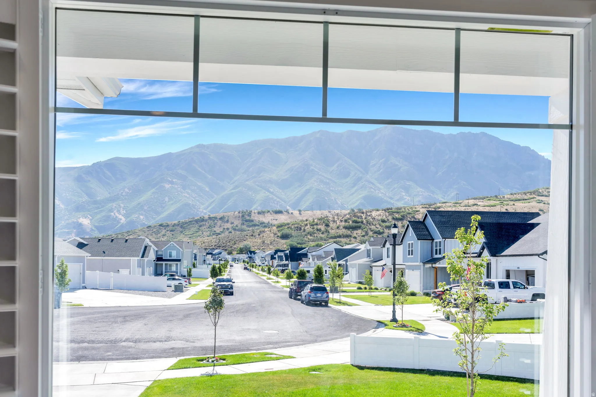 Expansive mountain backdrop visible through large windows with plantation shutters