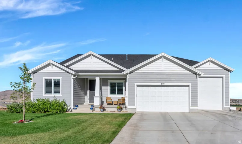 Single-story residence featuring a covered front porch, and a two-car garage with an additional RV Height Garage