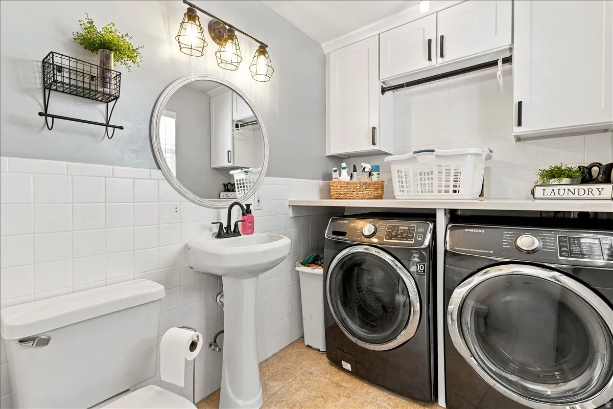 Pedestal sink with a circular mirror and industrial-style vanity lighting/ also laundry room