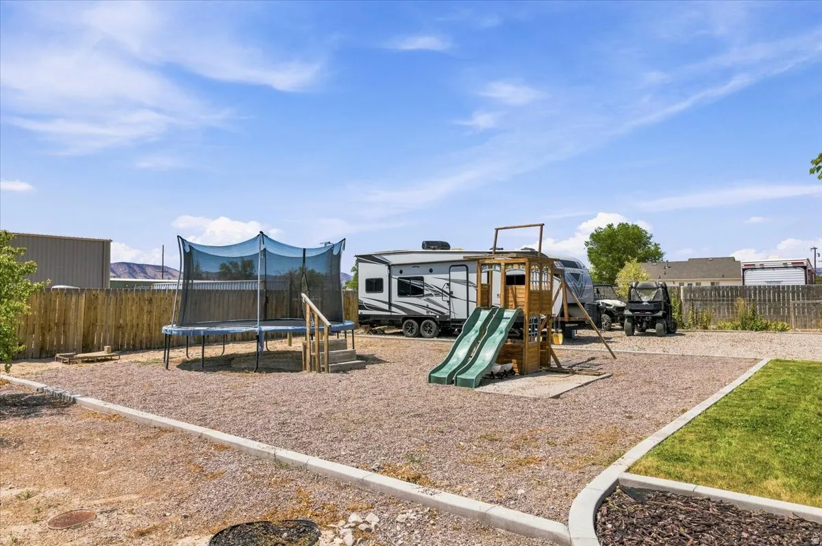 Expansive gravel area featuring a wooden playset with dual slides