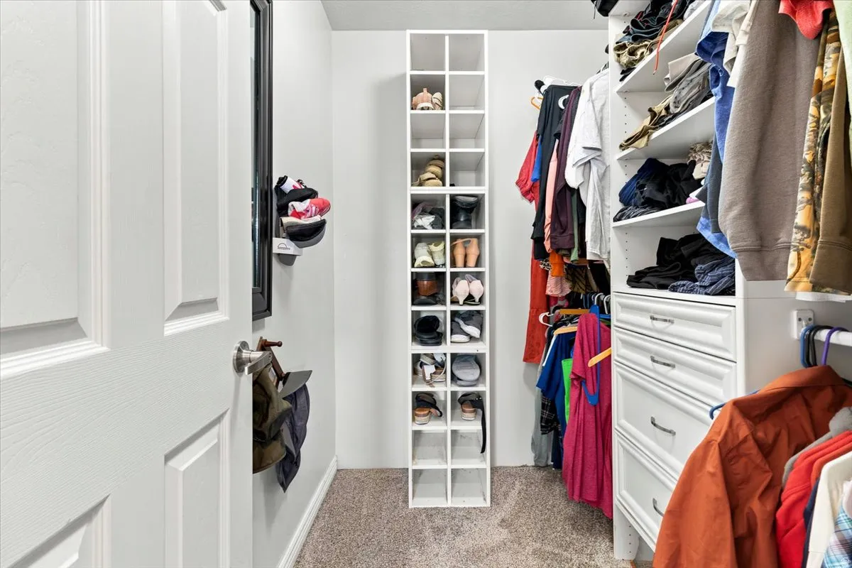 Custom closet system featuring multiple hanging rods, adjustable shelving, and integrated drawers