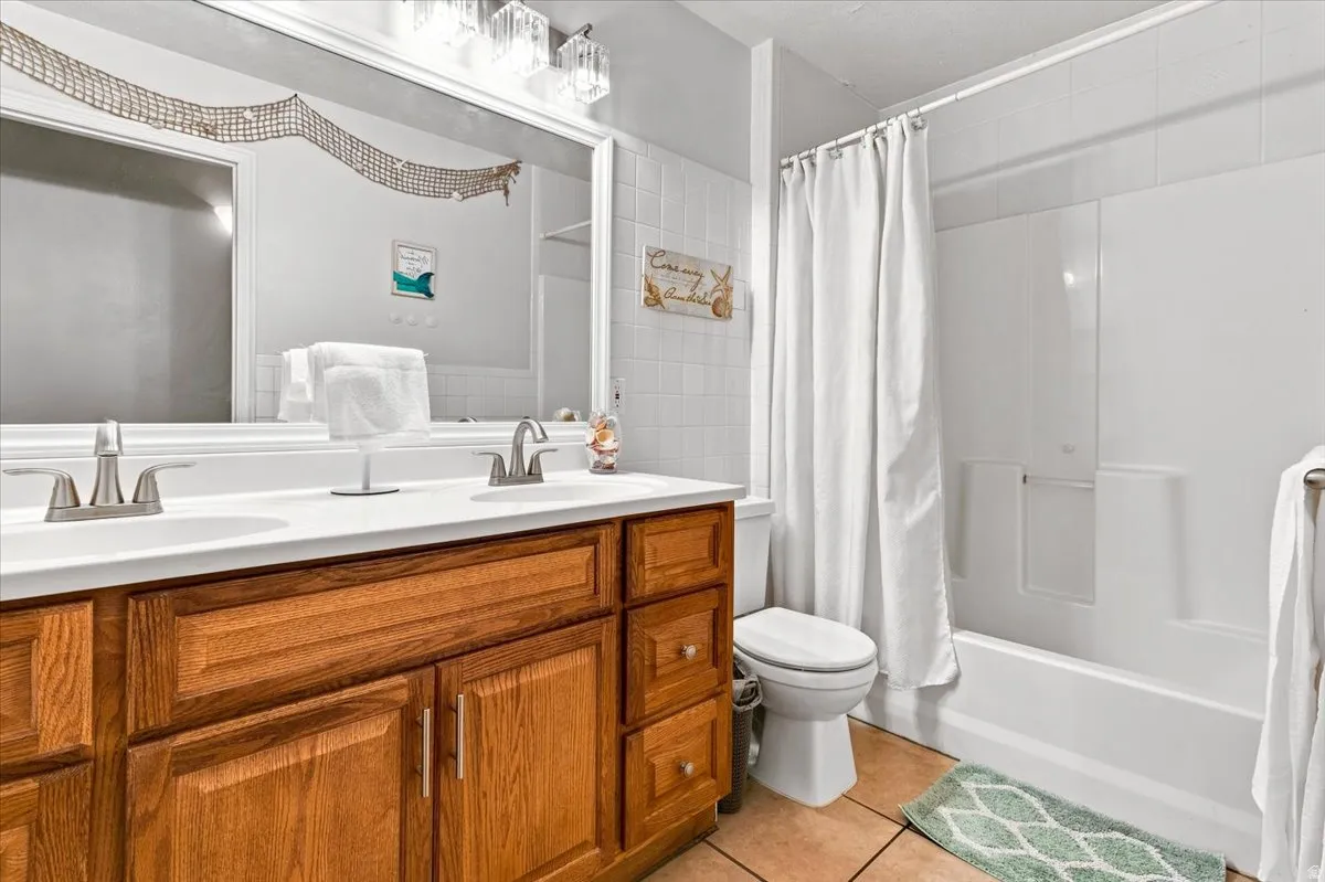 Double vanity with white countertop, chrome fixtures, and wood cabinetry