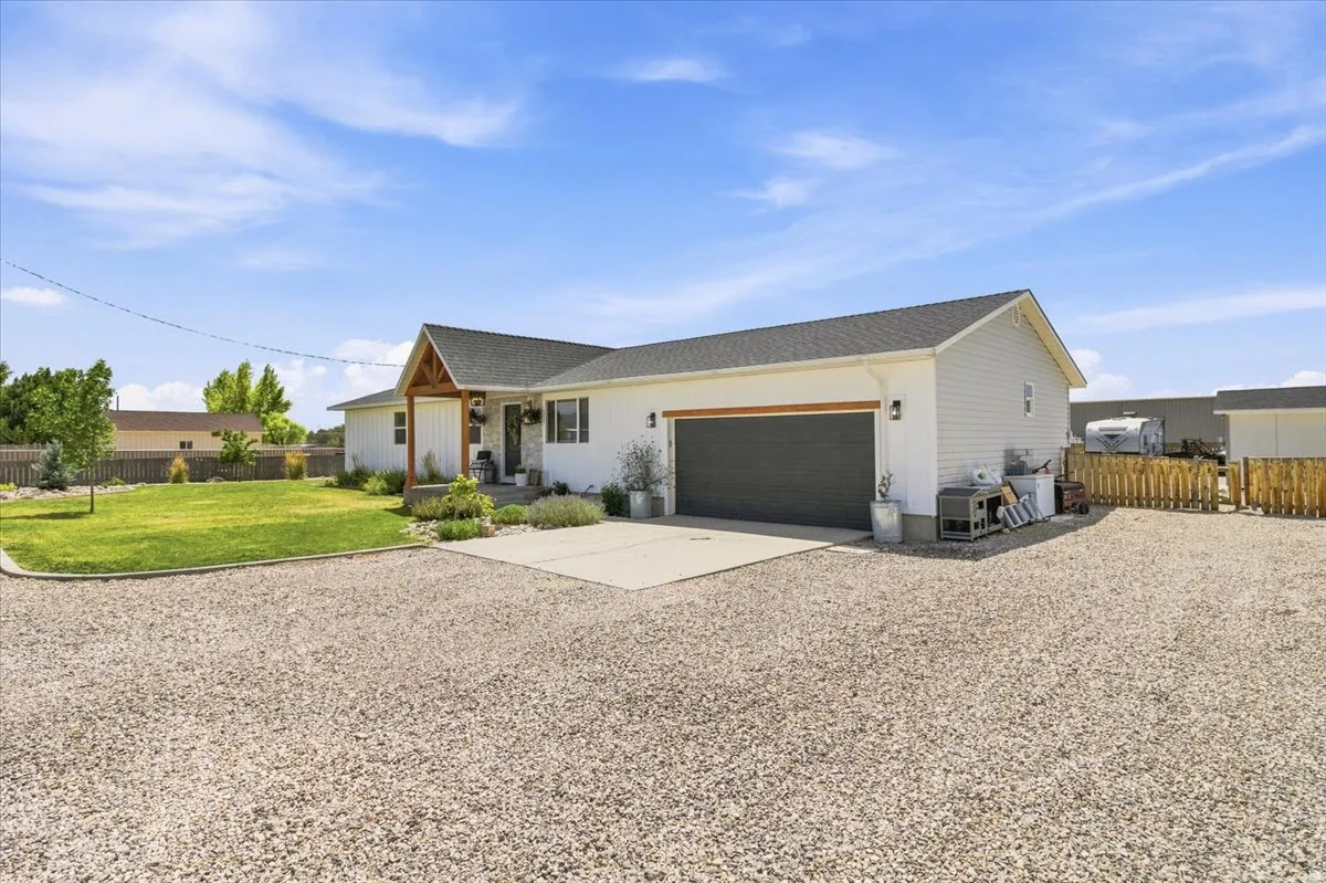 Ranch-style residence featuring white siding and a dark shingle roof