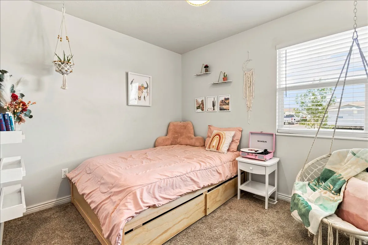 Carpeted room with light gray walls, a window with horizontal blinds, and a ceiling-mounted light fixture