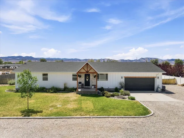 Ranch-style residence featuring a white board and batten exterior and a dark asphalt shingle roof