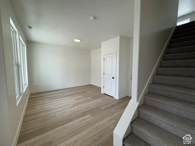 Wood-finish flooring, white paneled doors, recessed lighting, and carpeted stairs