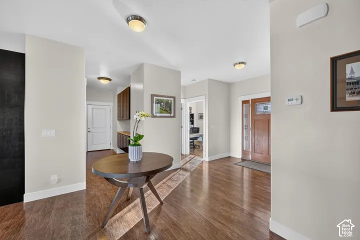 Entryway featuring rich wood-finish flooring, a solid wood front door with decorative glass inserts, and recessed lighting