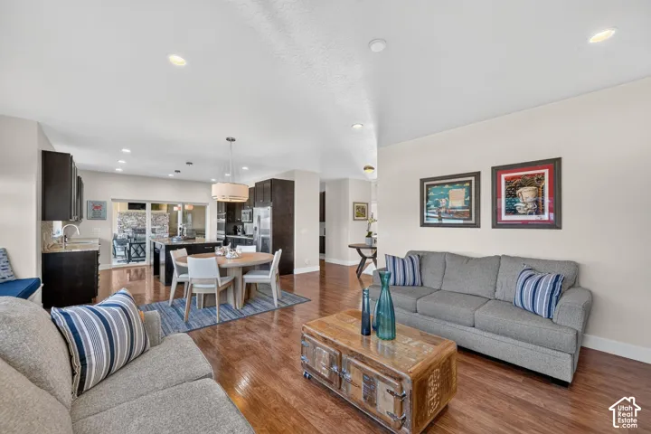 Open-concept living space featuring wood-finish flooring, recessed lighting, and light-toned walls