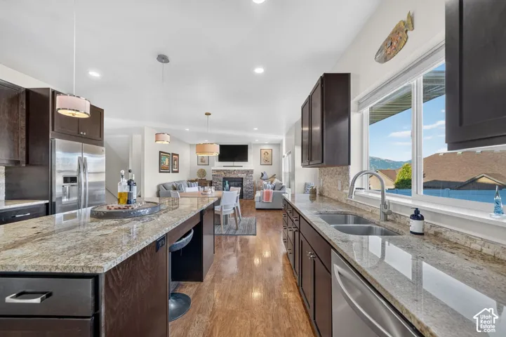 Kitchen featuring granite countertops, dark wood-finish cabinetry, and stainless steel appliances