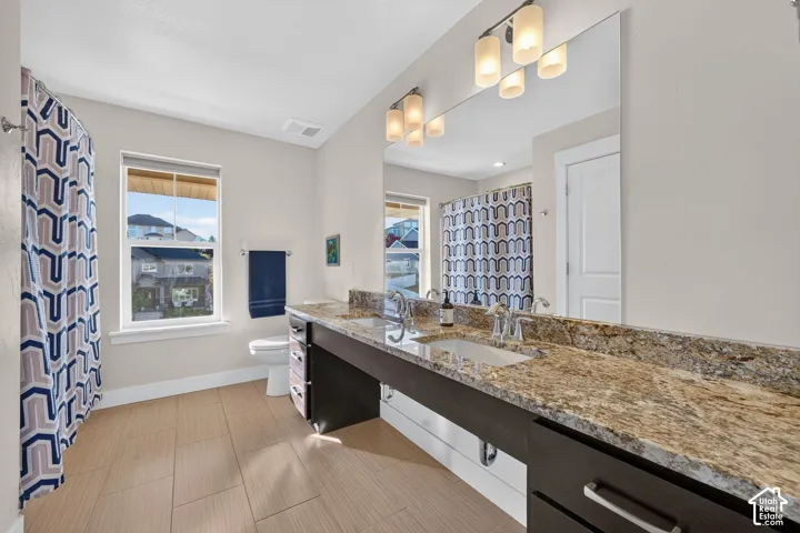 Double vanity featuring a light-toned countertop, two integrated sinks, and individual faucets