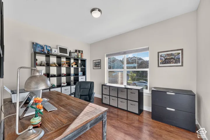 Versatile room featuring wood-finish flooring, neutral wall tones, a large window, and a flush mount ceiling light