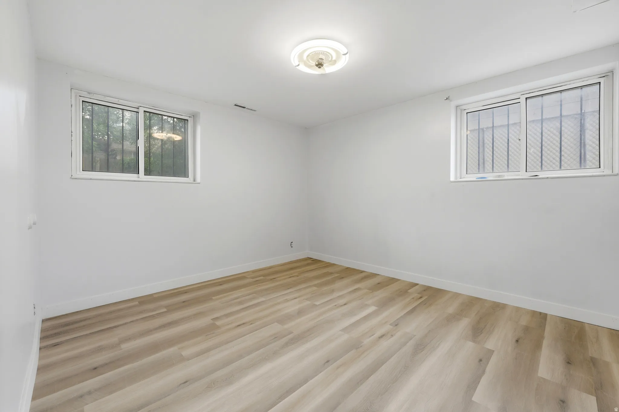 Room featuring wood-finish flooring, white painted walls, and white trim
