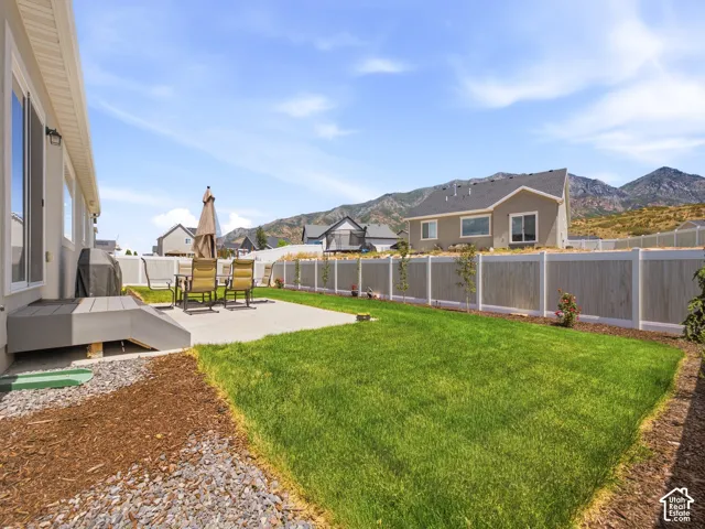 Expansive backyard featuring a manicured lawn, a concrete patio, and a composite deck with steps