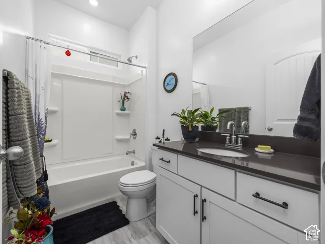 Bathroom featuring a white vanity with flat-panel doors, dark countertop, and an undermount sink