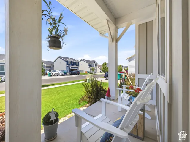 Covered front porch featuring white columns and a light-colored siding exterior