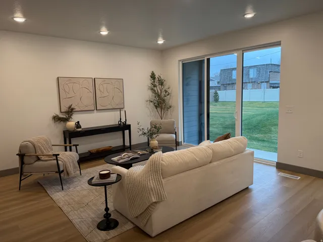 Open-concept living area featuring wood-finish flooring, recessed lighting, and white baseboards