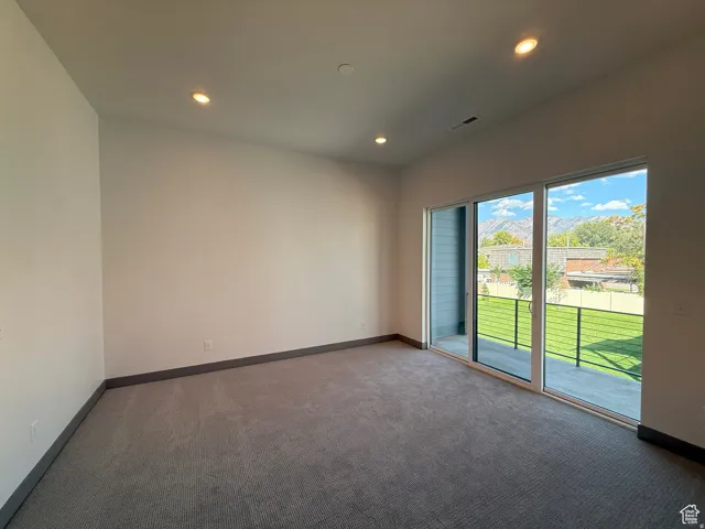 Spacious room featuring neutral carpeting and white painted walls