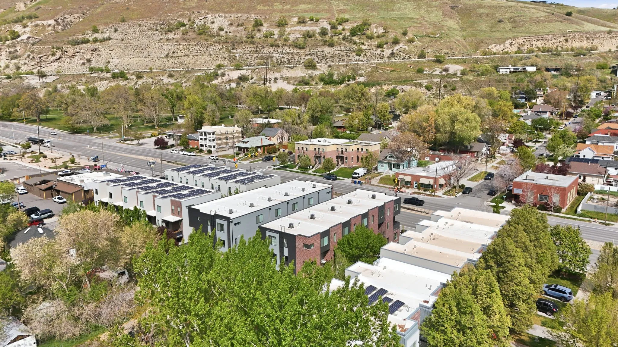 Aerial perspective showcasing a collection of modern townhomes with flat roofs and solar panel installations