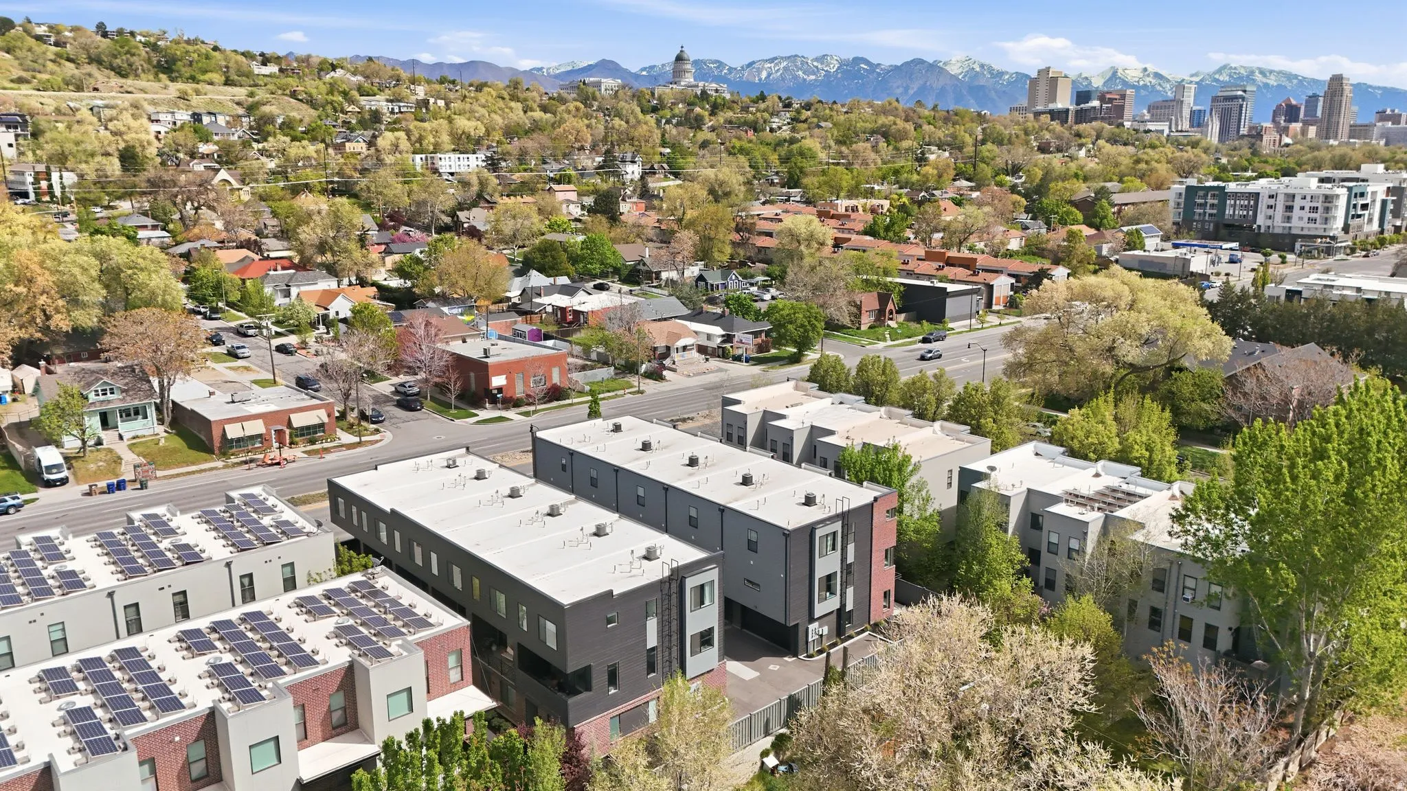 Modern multi-story dwellings featuring flat roofs and solar panel installations