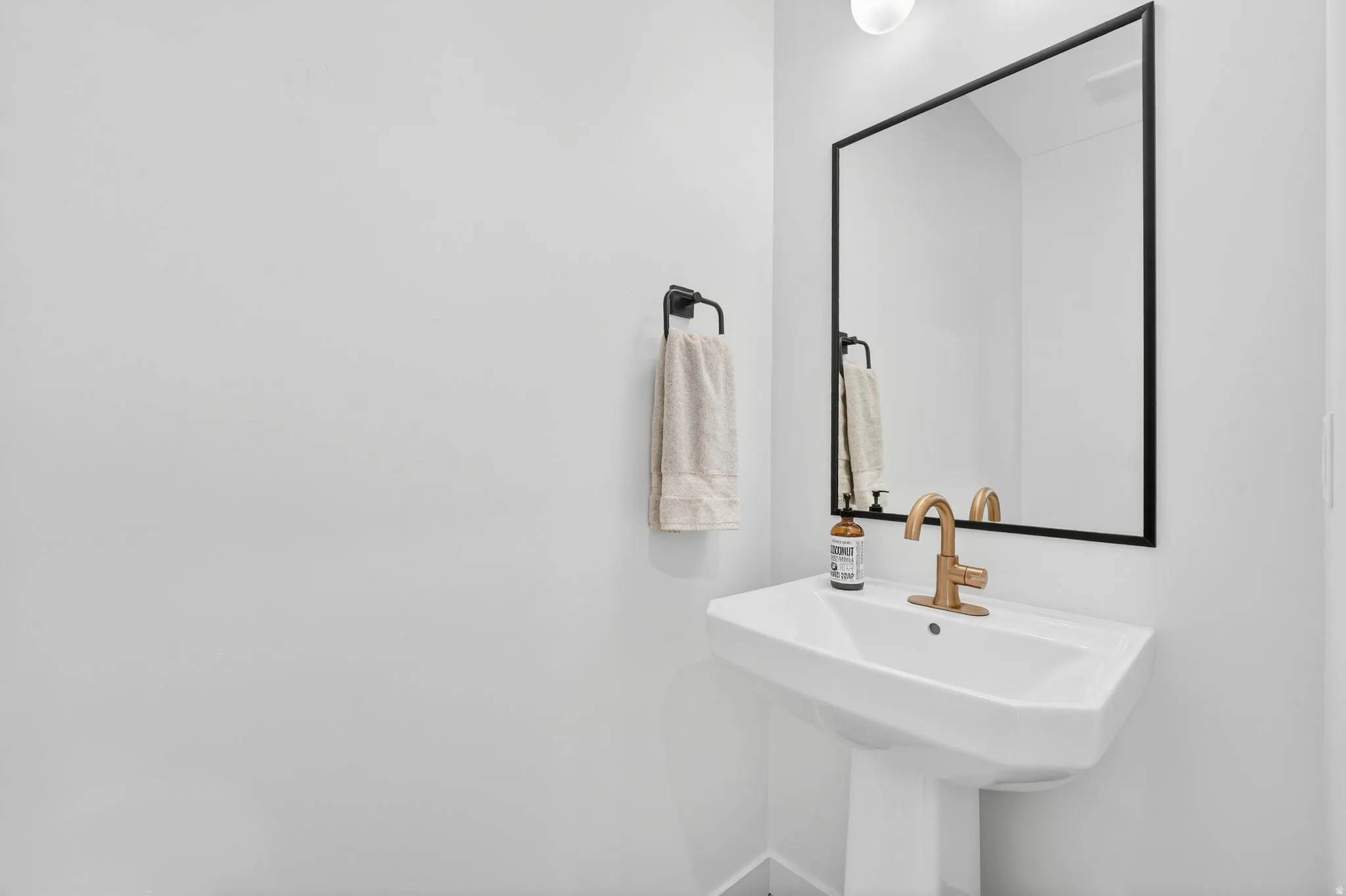 Pedestal sink featuring a gold-finish faucet