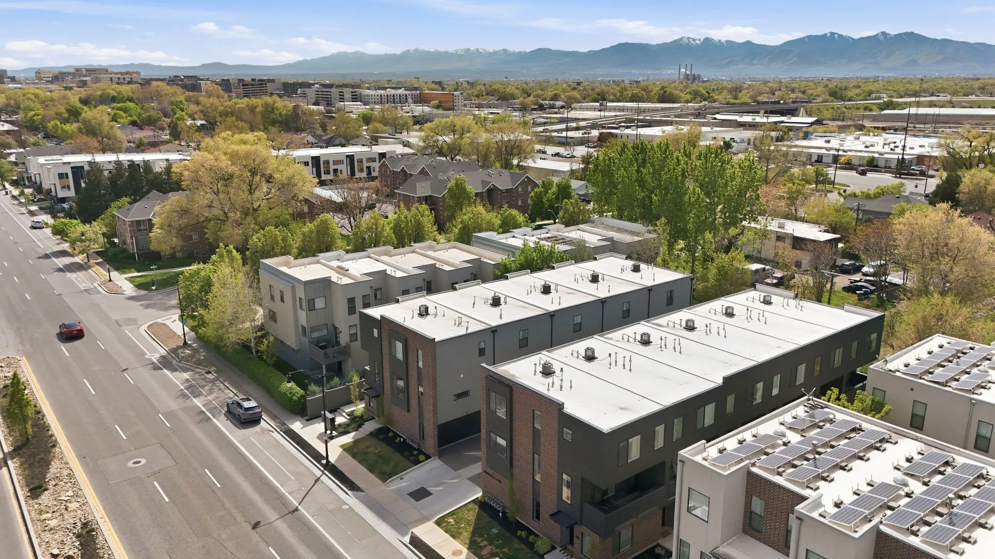 Contemporary multi-level townhomes featuring clean lines, flat roofs, and a mix of brick and dark-toned siding
